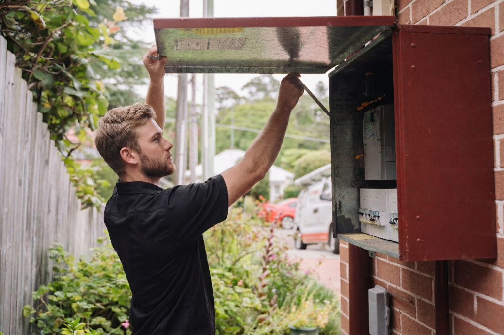 Electrician installing downlights in a Darling Harbour home